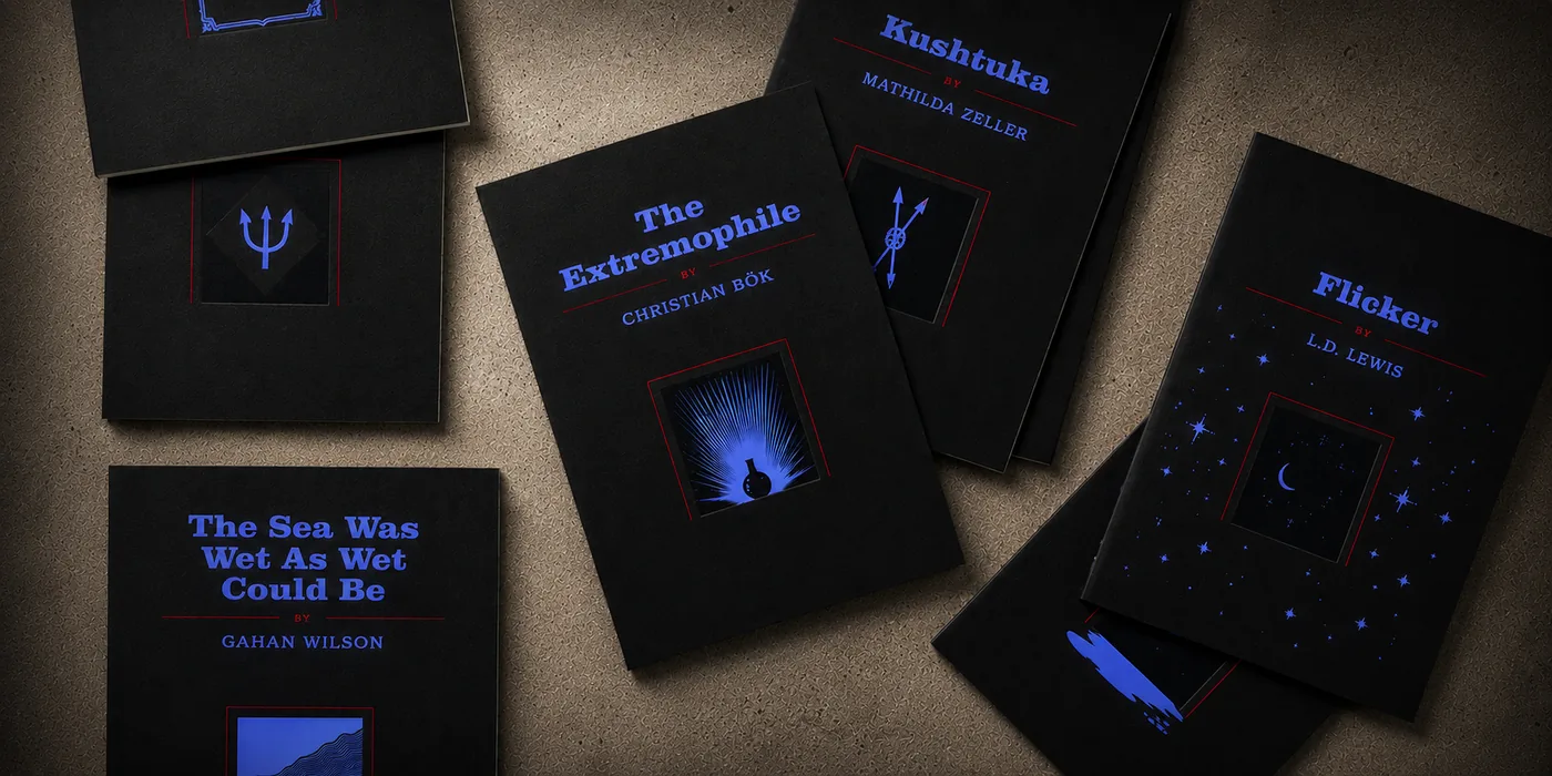 The Ghost Box contents — matte black story booklets with blue and red ink covers, including ‘The Sea Was Wet As Wet Could Be’ by Gahan Wilson, ‘The Extremophile’ by Christian Bök, ‘Kushtuka’ by Mathilda Zeller, and ‘Flicker’ by L.D. Lewis, scattered across a warm cork surface