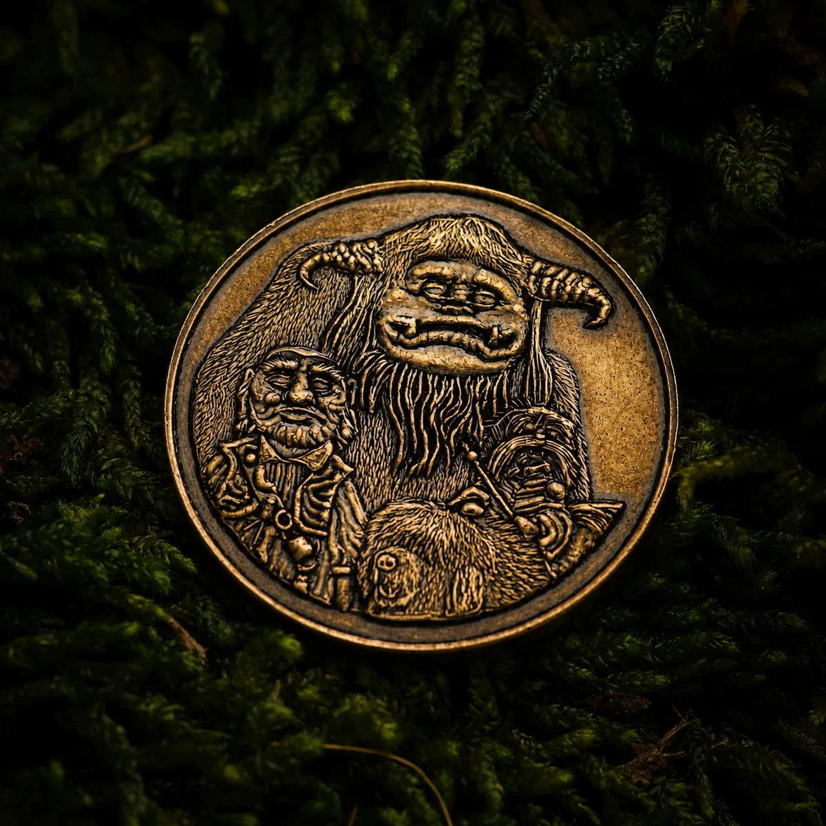 Labyrinth token — an antiqued brass coin engraved with a horned goblin king cradling two smaller creatures, on dark moss