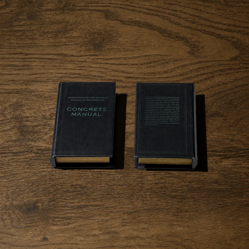 Hollowed book — Concrete Manual, front and back covers of the hardcover book side by side on a wood surface
